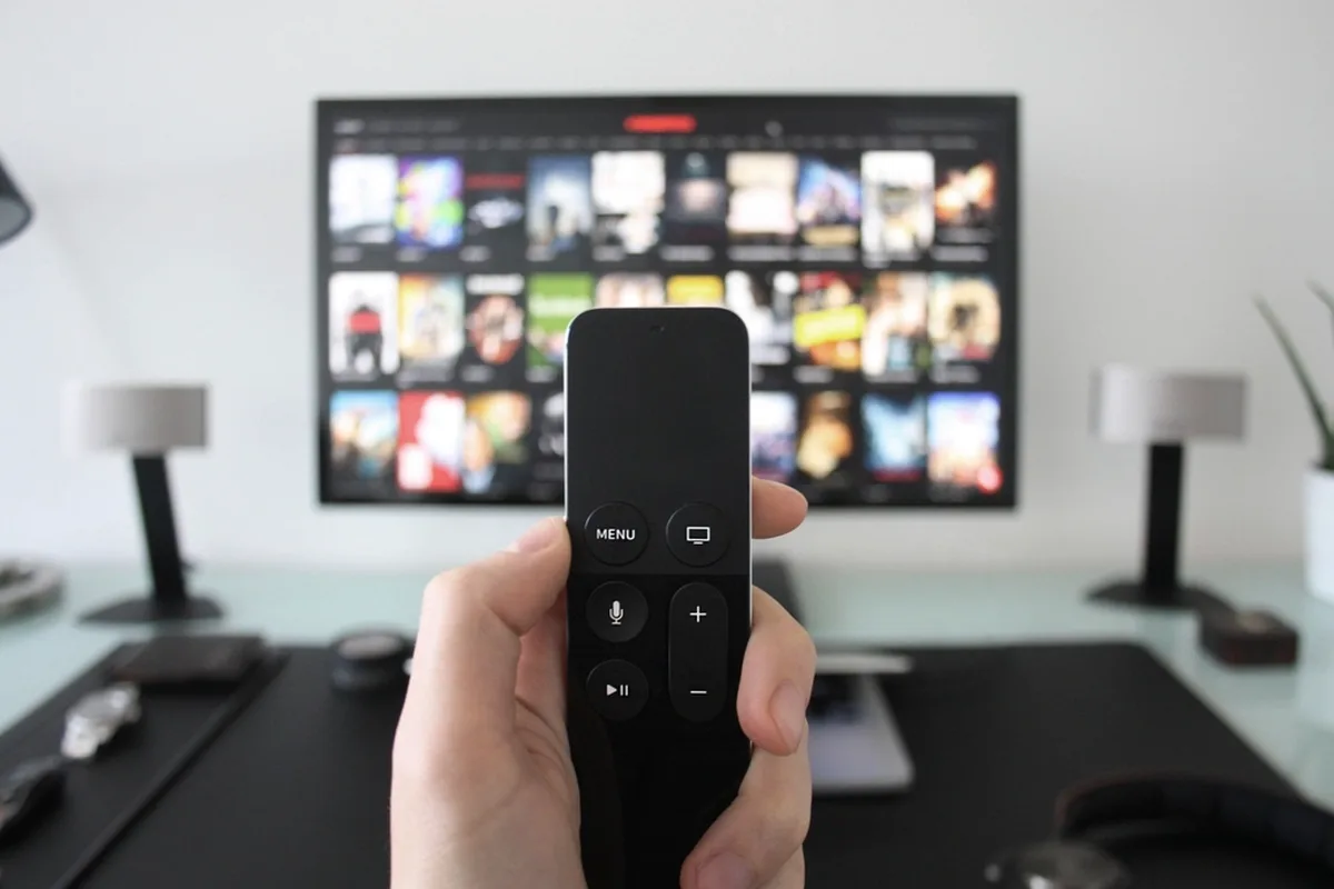 리모컨을 들고 TV 화면을 향하는 모습